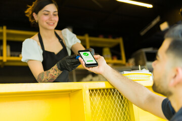 Customer paying for his fast food at the food truck - obrazy, fototapety, plakaty