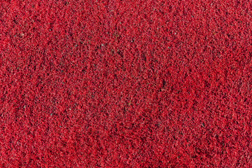 Red plastic synthetic artificial grass background texture which is used on child playground areas...