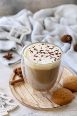 Seasonal winter concept with hot drink. Latte spice coffee, warm pullover and Christmas decor on gray background