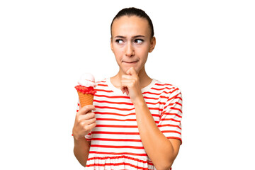 Young Arab woman with a cornet ice cream over isolated background having doubts and thinking