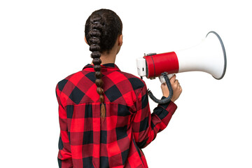 Young Arab woman over isolated background holding a megaphone and in back position - obrazy, fototapety, plakaty