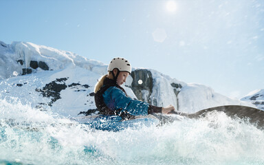 Naklejka na ściany i meble Woman in a kayak sails on a mountain river. Whitewater kayaking, extreme kayaking.