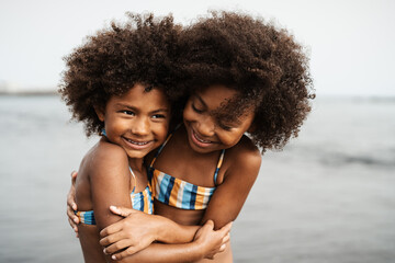 Happy African children having fun on the beach during summer holidays - Family love and travel vacation lifestyle concept
