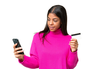 Young African American woman over isolated background buying with the mobile with a credit card