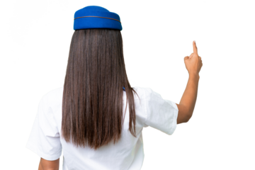 Airplane stewardess African american woman over isolated background pointing back with the index finger