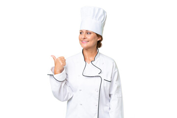 Middle-aged chef woman over isolated background pointing to the side to present a product