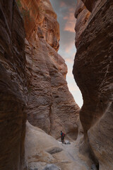 hiker with backpack walking on wadi ghuweir canyon in dana natural reserve - obrazy, fototapety, plakaty