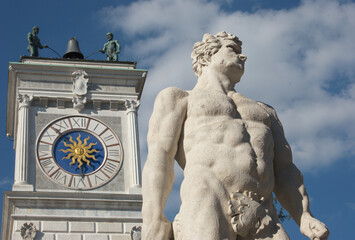A view of Piazza Libertà in Udine, North Italy. Details of clock tower and Hercules statue