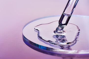 Pipette with sample of cosmetic product in petri dish on holographic background, iridescent...