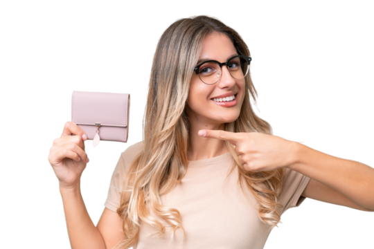 Young Uruguayan woman holding a wallet over isolated background and pointing it