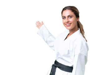 Young Uruguayan woman doing karate over isolated background extending hands to the side for inviting to come © luismolinero