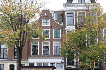 Amsterdam Zwanenburgwal Canal Traditional Brick House Facade with Bell Gable and Autumn Trees Close Up, Netherlands