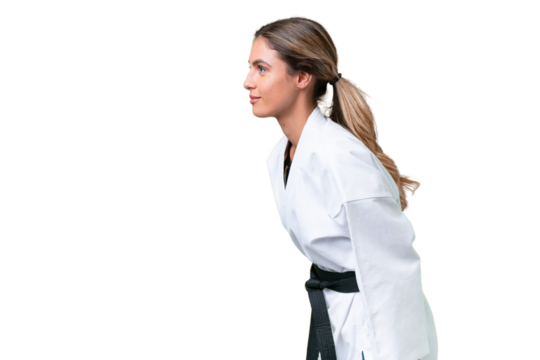 Young Uruguayan woman over isolated background doing karate and saluting