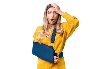 Young Uruguayan woman with broken arm and wearing a sling over isolated background with surprise expression