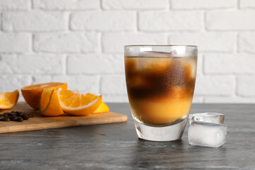 Tasty refreshing drink with coffee and orange juice on grey marble table, space for text