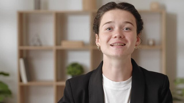 Head shot portrait smiling woman looks at camera communicates remotely by videoconferencing.