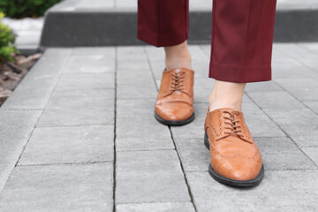 Woman in red pants and fashionable shoes walking on city street, closeup. Space for text