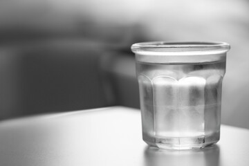 Glass of pure water on light table against blurred background, space for text