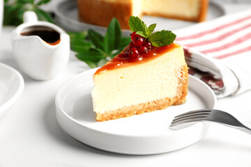 Piece of delicious caramel cheesecake with red currants and mint served on white marble table, closeup
