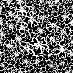 Monochrome abstract floral seamless repeat pattern. Random placed, irregular flower heads all over surface print on black background.