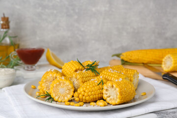 Plate with tasty cooked corn cobs on table indoors