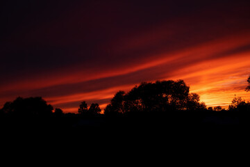 Orange and scarlet sunset in nature. The setting sun over the horizon