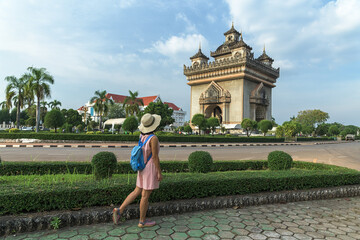 Fototapeta premium Young woman walking in Patuxai (Patuxay), Victory Gate, the Arc de Triomphe of Vientiane, a war monument dedicated to those who fought in the struggle for independence from France in Laos.