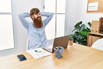 Young irish businessman smiling happy relaxed with hands on head at the office.