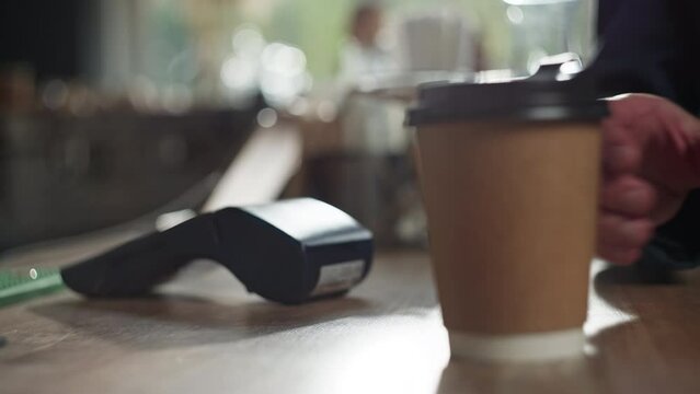 Close-up of a man paying for coffee by phone in a cafe. Pay by PayPass at the terminal. Small business work. High quality 4k footage