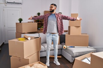 Young hispanic man smiling confident standing with arms open at new home