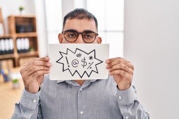 Middle east man with beard holding banner with swear words sticking tongue out happy with funny expression.
