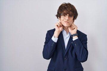 Hispanic business young man wearing glasses smiling pulling ears with fingers, funny gesture. audition problem