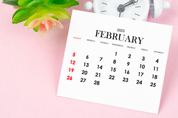 The February 2023 Monthly calendar for 2023 year with vintage alarm clock on pink colour background.