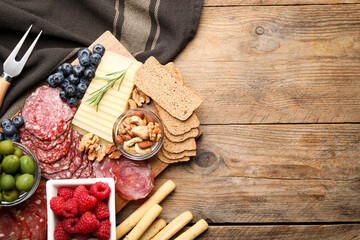 Snack set with delicious Parmesan cheese on wooden table, flat lay. Space for text