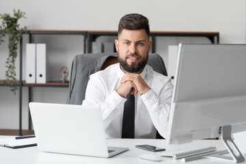 Handsome bank manager working at table in office