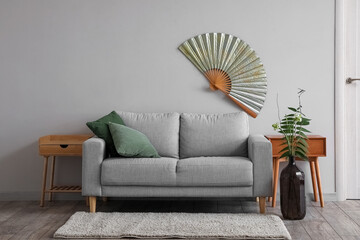 Interior of modern living room with sofa, tables and ikebana