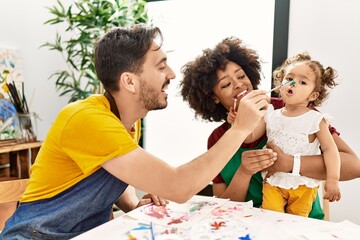 Obraz premium Couple and daughter smiling confident painting child nose at art studio