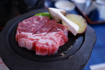 Sliced raw beef meat and variety of vegetable on the black grill plate for Yakiniku, isolated on black background. Top view - 焼肉 野菜 ステーキ 鉄板