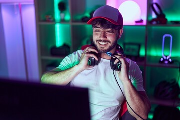 Young hispanic man streamer smiling confident using computer at gamin room