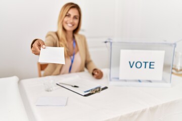 Young caucasian politic party worker smiling happy holding vote at electoral college.