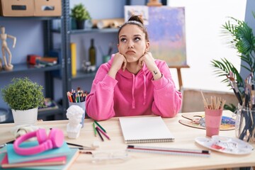 Young woman artist stressed drawing on notebook at art studio