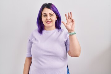 Fototapeta na wymiar Plus size woman wit purple hair standing over isolated background showing and pointing up with fingers number four while smiling confident and happy.