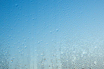 Drop of water on glass, misted window. Blue abstract background, texture.