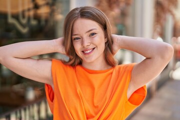 Young woman smiling confident relaxed with hands on head at street