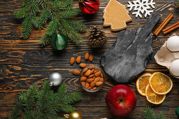 Cutting board and ingredients for preparing Christmas cookies on wooden background