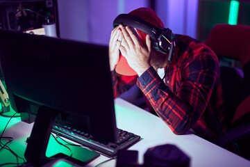 Young caucasian man streamer stressed using computer at gaming room