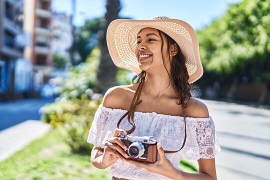 Young african american woman tourist smiling confident using camera at park