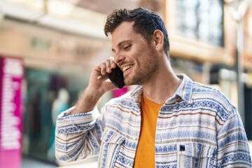 Young hispanic man smiling confident talking on the smartphone at street