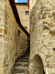 Naklejka premium Stairs leading up between the walls of ancient Rupa fortress in Romania. Fortress was built on ruins of former Dacian defensive structure. Selective focus.