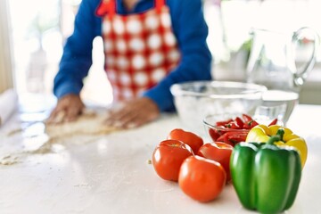 Senior man cooking pizza dough with hands at kitchen